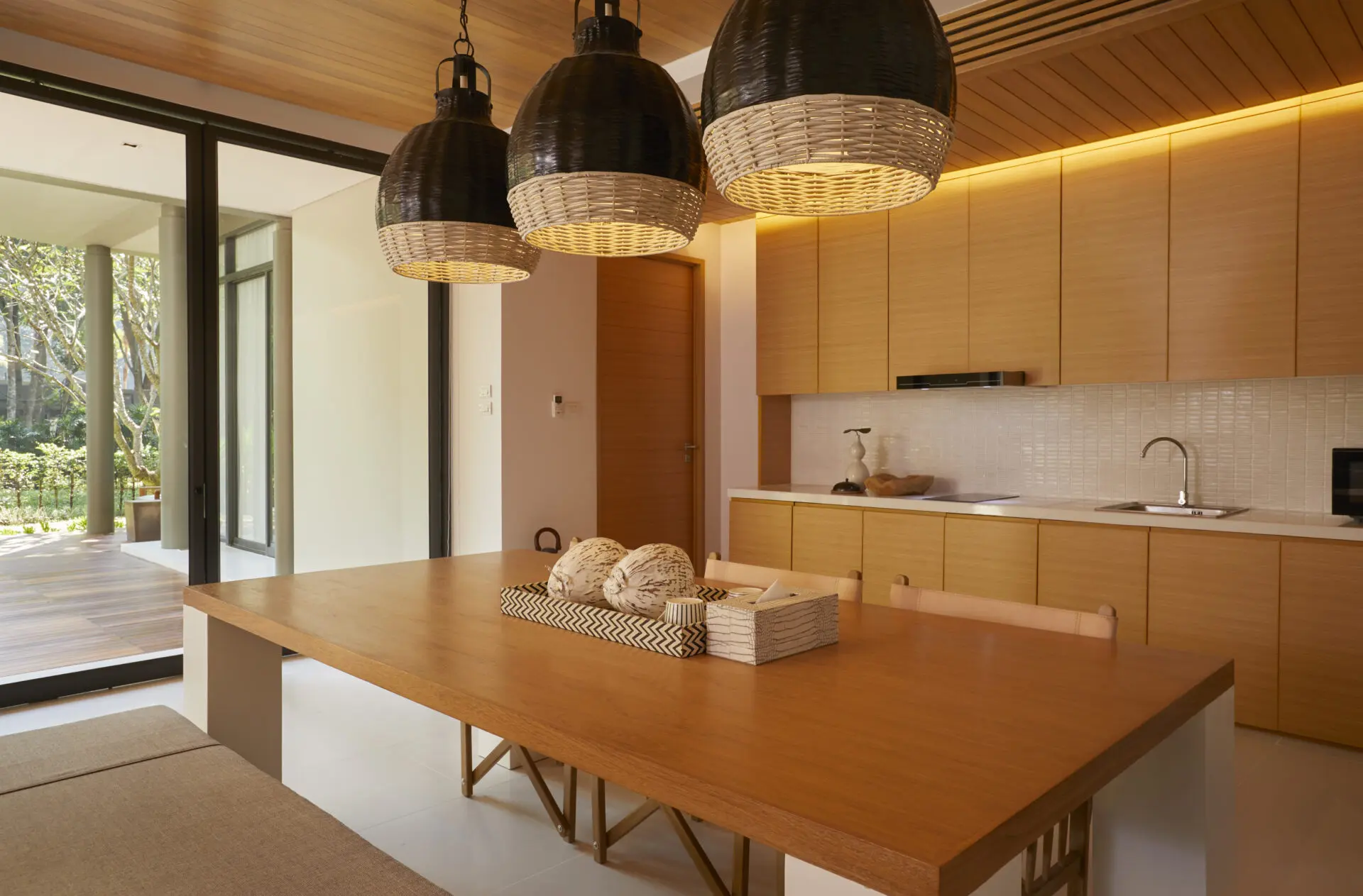 Stylish villa living room with floor-to-ceiling windows capturing peaceful outdoor scenery.