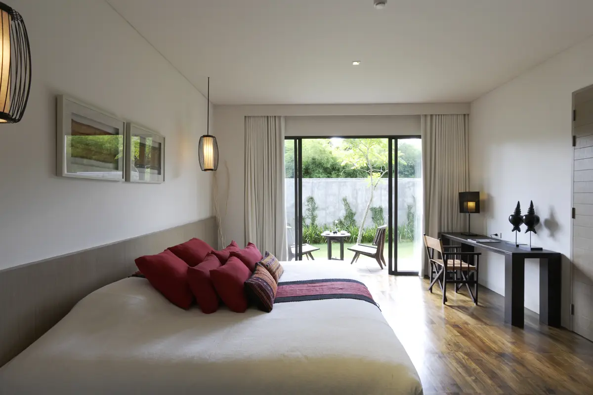 Suite living room with large windows capturing soft natural light and a tranquil resort atmosphere.