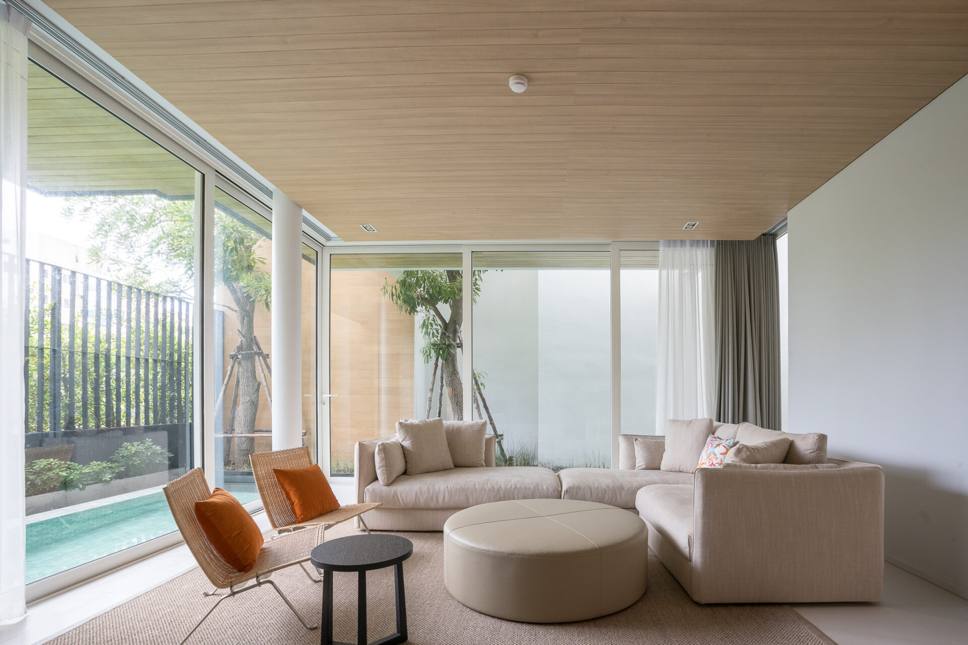 Cozy indoor seating corner with contemporary décor and pool-facing views.