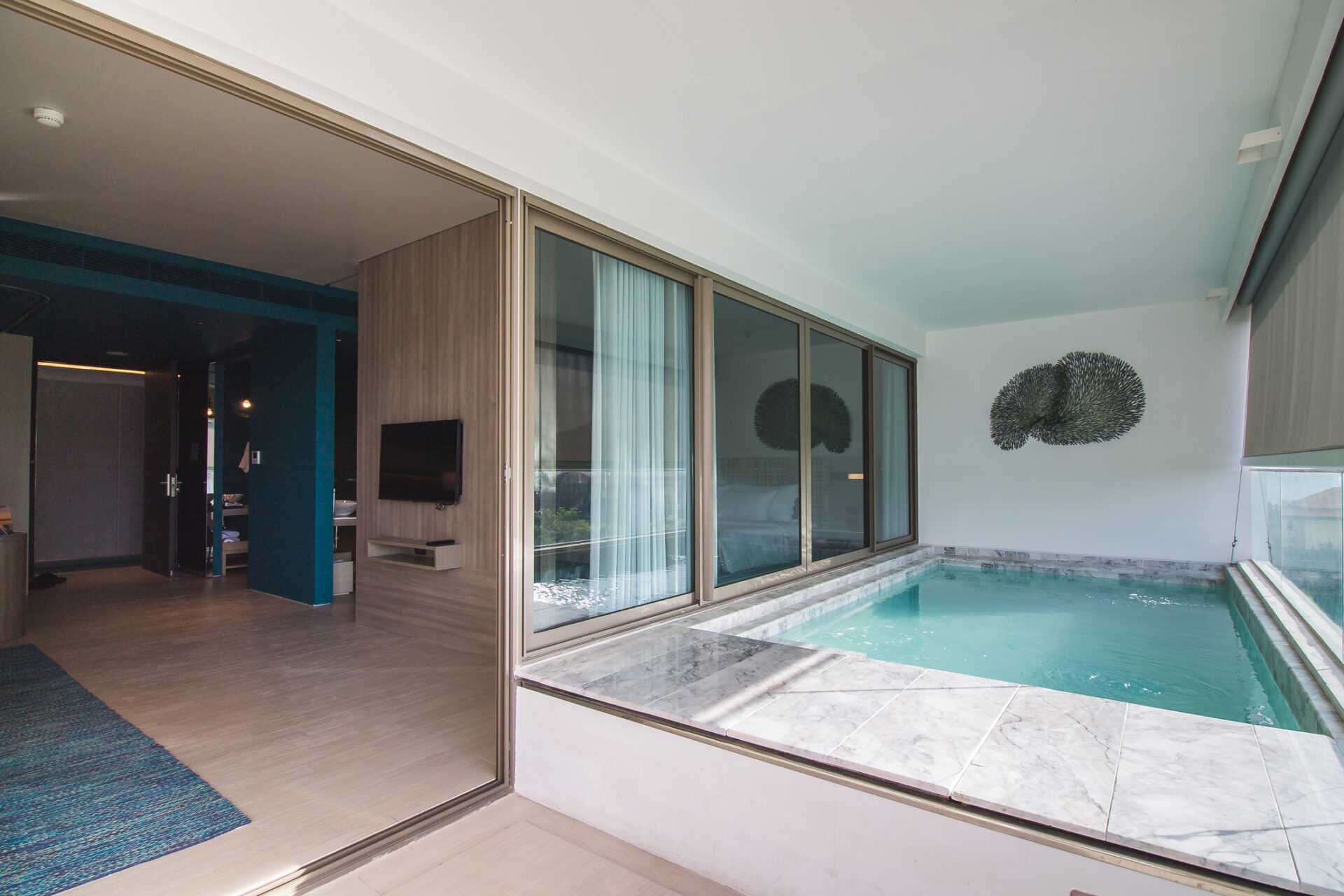 Cozy family pool suite with bright natural lighting and an intimate private pool for relaxing moments.