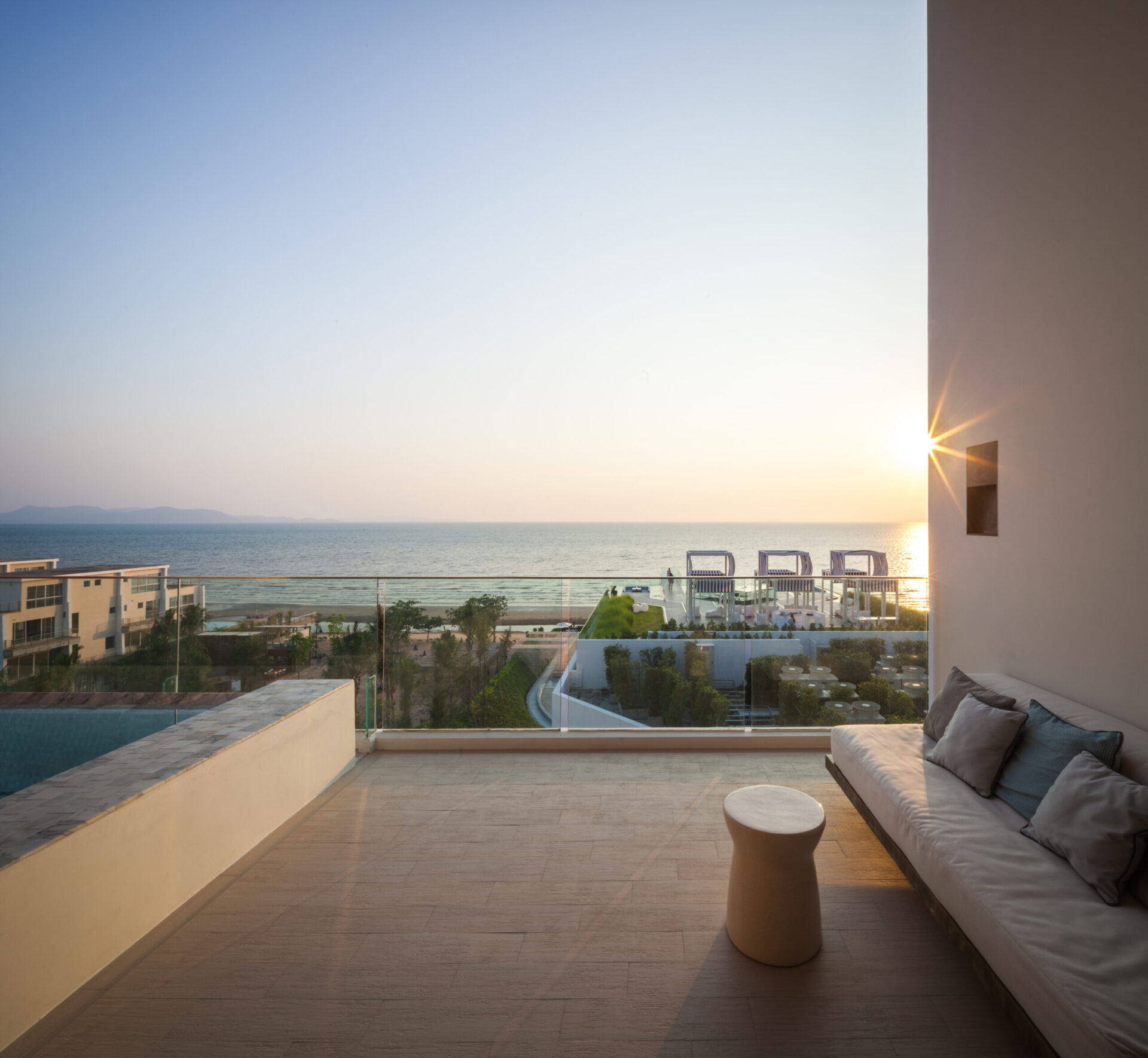 Outdoor sky pool terrace with loungers and direct sea view, perfect for sunset relaxation.