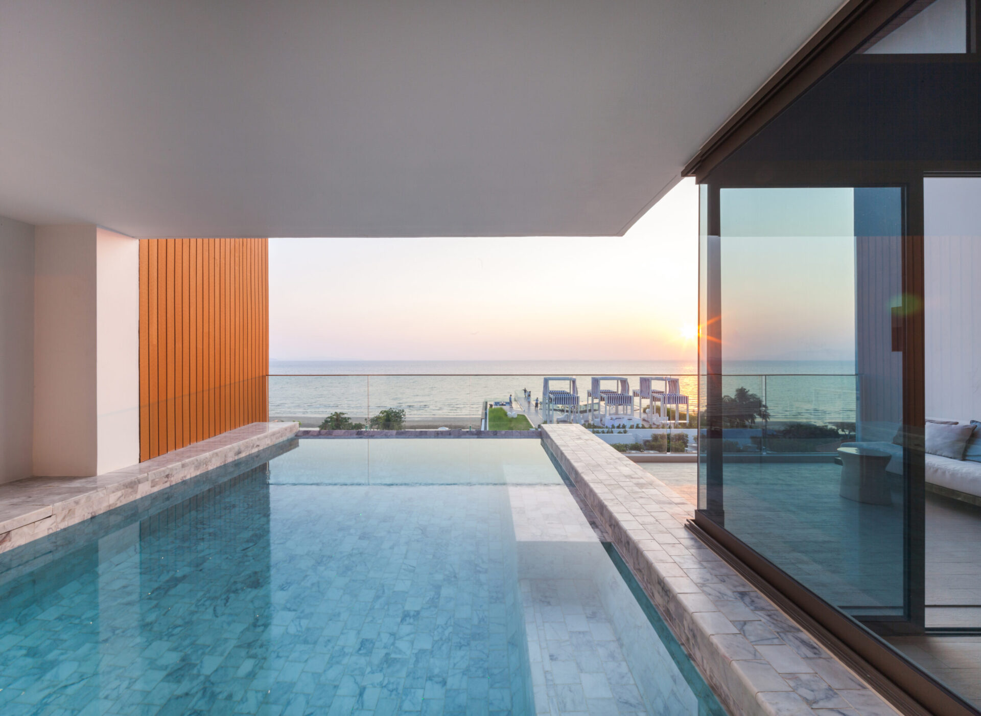 Spacious living and dining area with soft natural light and ocean backdrop inside the Sky Pool Villa.