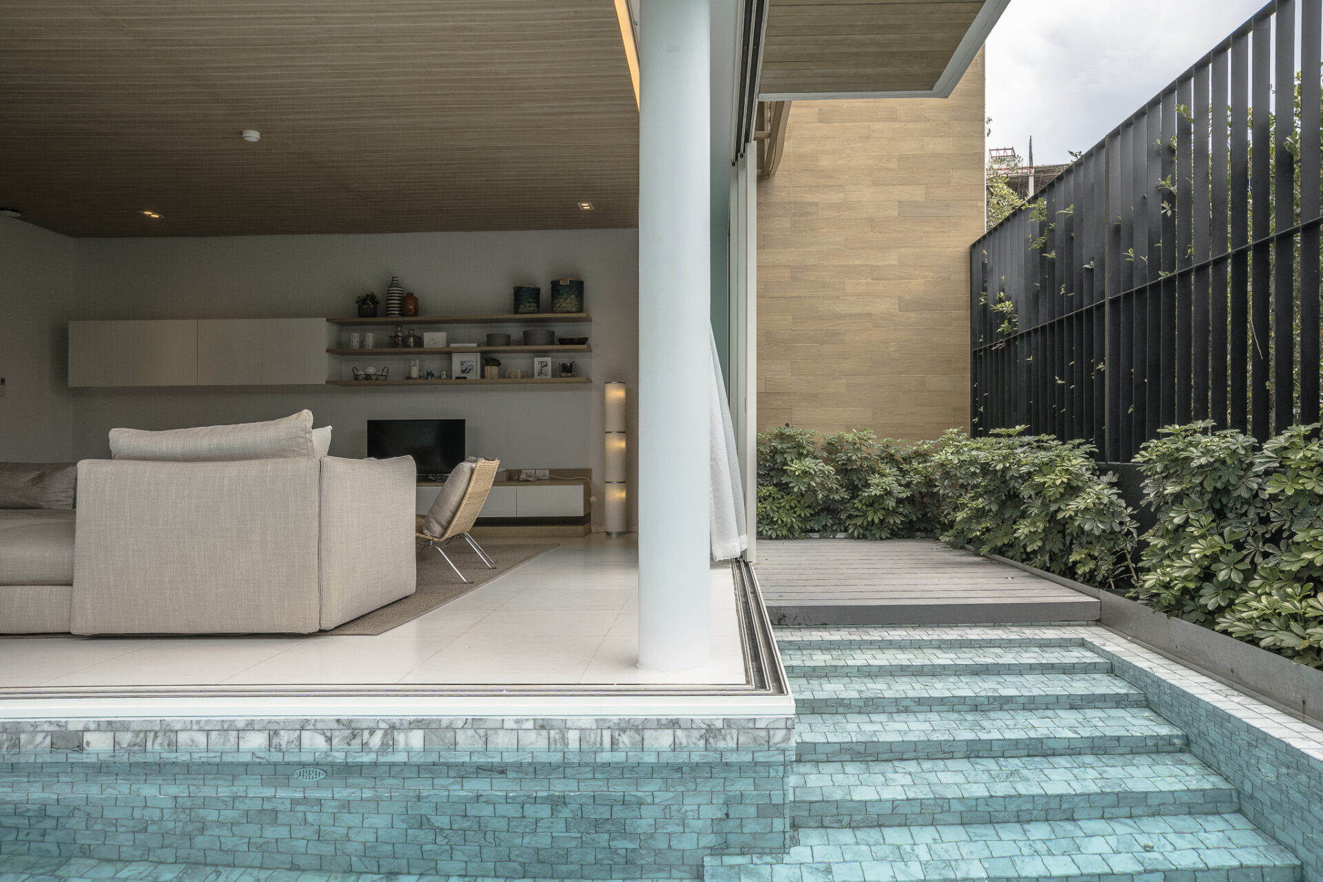 Elegant living area with warm natural light and direct pool view, perfect for group gatherings.