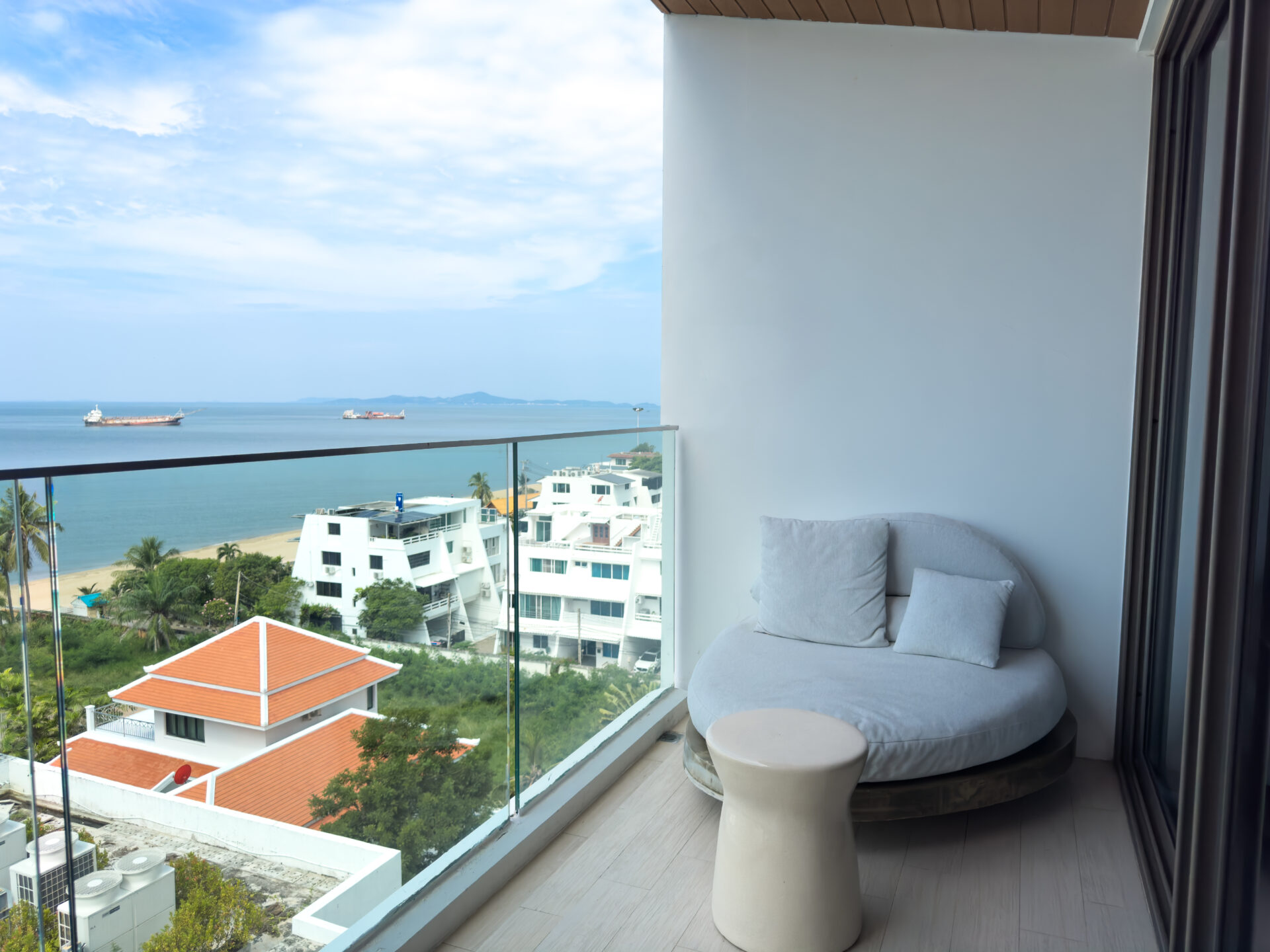 Seascape Ocean View room with serene décor and a wide window framing the sea, offering a relaxing escape at a seaview hotel in Pattaya Na Jomtien.